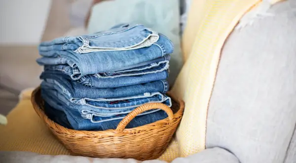 Stapel blauer Jeans in einem Korb. Die Frage, wie oft Jeans waschen, beschäftigt viele.
