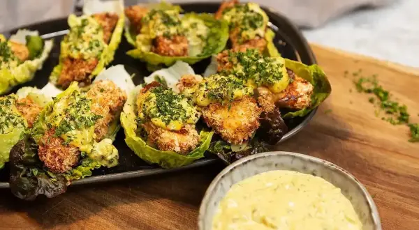 Krispiga bitar i salladsblad toppade med en krämig sås. Perfekt tillbehör till ditt remouladsås recept.
