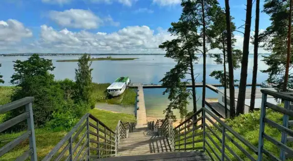 Idealne miejsce na mazury na weekend. Drewniane schody prowadzą do jeziora z łodzią i pomostem.