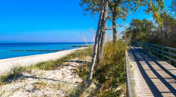 Drewniany deptak nad morzem w Kołobrzegu, idealne miejsce na spacer. Kołobrzeg atrakcje dla dorosłych to także piękne plaże i spokój.