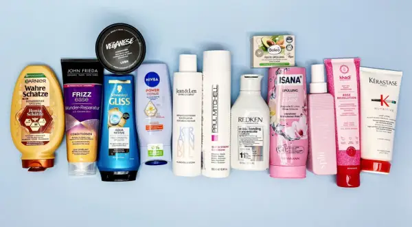 Eine Auswahl an Haarspülungen, darunter Produkte von Garnier, John Frieda und Nivea, einige mit Inhaltsstoffen wie Stearamidopropyl Dimethylamine für glänzendes Haar.