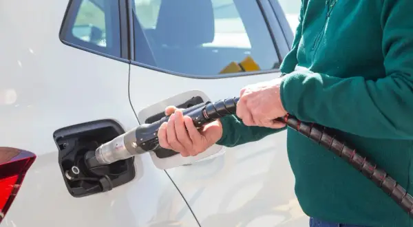 Tankowanie samochodu CNG i hybryda: co to za paliwo? Dłoń trzyma pistolet do tankowania gazu ziemnego.