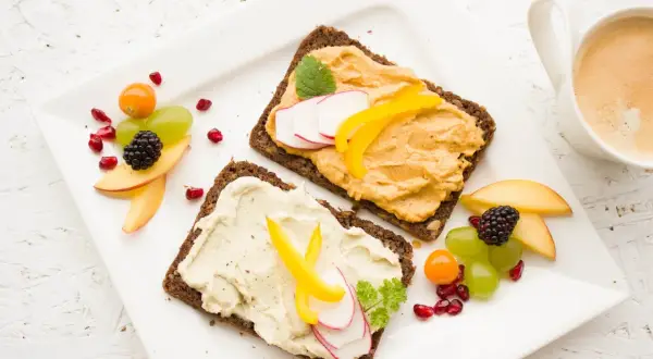 Zdrowe śniadanie dla przyszłej mamy: ciemne pieczywo z pastą warzywną, owocami i kawą. Idealna dieta w ciąży.