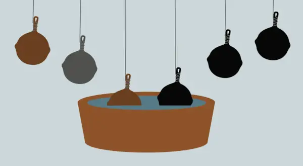 En rostig muurikka doppas i en balja. Andra muurikkor hänger ovanför, vissa mörka, andra grå.
