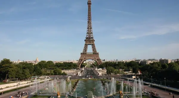 La Tour Eiffel se dresse fièrement, invitant à la découvrir. Des fontaines jaillissent, des gens se promènent, une belle journée pour monter à la Tour Eiffel.