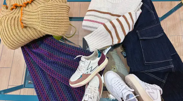 Sneakers: cosa sono? Scarpe comode e alla moda, perfette per ogni outfit. Ecco un esempio di look casual con maglioni, jeans e una borsa.