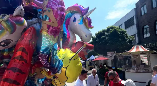 Bunte Ballons mit Einhorn und Meerjungfrau beim Stadtfest Bensberg. Menschen schlendern an Ständen vorbei.