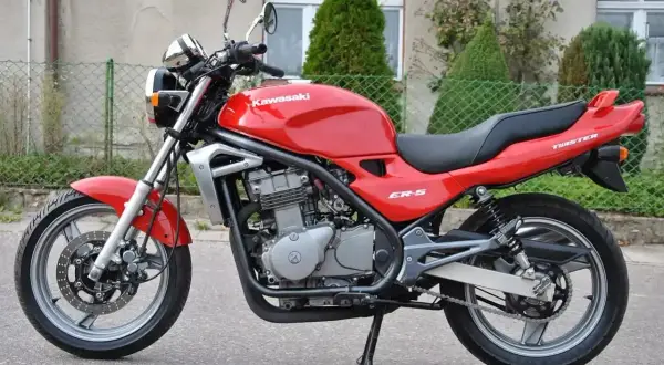 Czerwony Kawasaki ER-5, gotowy do jazdy po miejskich ulicach.
