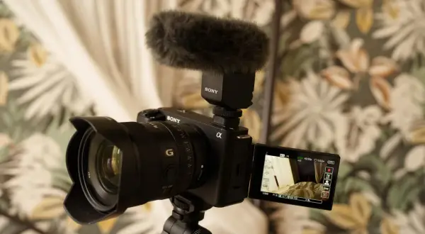 Kamera Sony z mikrofonem na statywie, gotowa do nagrywania. Idealny sprzęt do tworzenia treści, np. vlogów.
