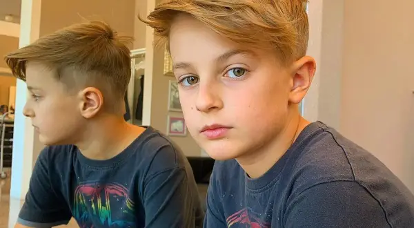 Ragazzo con taglio capelli bambino 11 anni, capelli biondi sfilati e ciuffo. Riflesso nello specchio.