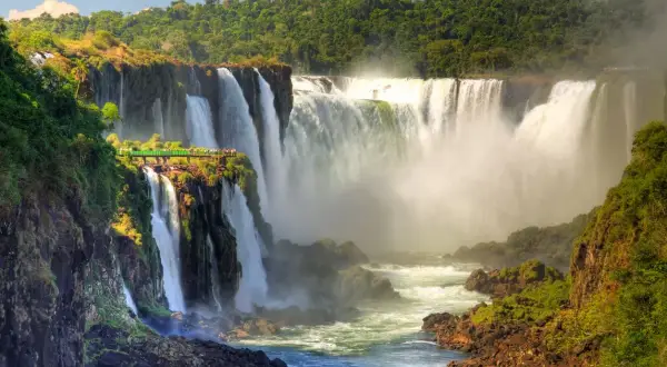 Impresionantes cascadas en América del Sur, con una pasarela verde para observar la majestuosidad del agua cayendo entre la exuberante vegetación.