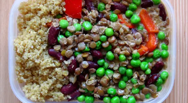 En näringsrik vegetarisk matlåda med quinoa, linser, bönor, ärtor och paprika. Perfekt för en hälsosam lunch!