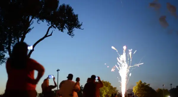 Gente observa fuegos artificiales, como en las mejores ferias de España.