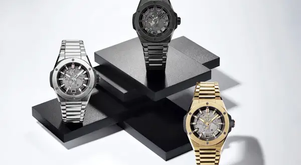Tres relojes de lujo, uno plateado, uno negro y uno dorado, exhiben la elegancia del **Big Bang reloj**.