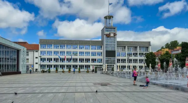 Plac miejski w Koszalinie, stare miasto, z ratuszem i fontannami w tle.
