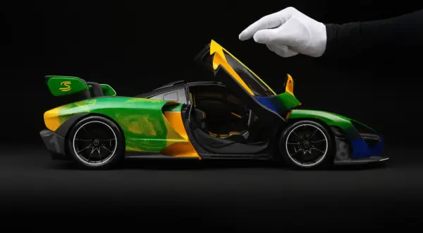 Model McLaren Senna w barwach Brazylii, z otwartymi drzwiami, gotowy do startu.