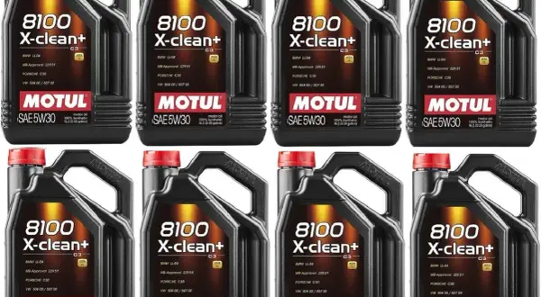 Cztery czarne kanistry oleju silnikowego Motul 8100 X-clean+ SAE 5W30 z czerwonymi nakrętkami.