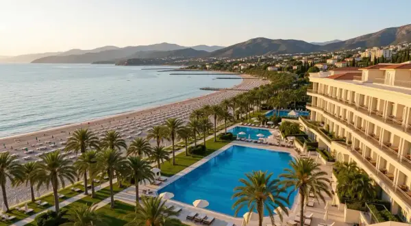Luksusowy hotel z atrakcjami dla dorosłych, z basenami i prywatną plażą, otoczony palmami, z widokiem na morze i góry.