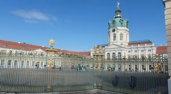Zamek Charlottenburg, cel jednodniowej wycieczki z Poznania. Złote zdobienia bramy i błękitne niebo.