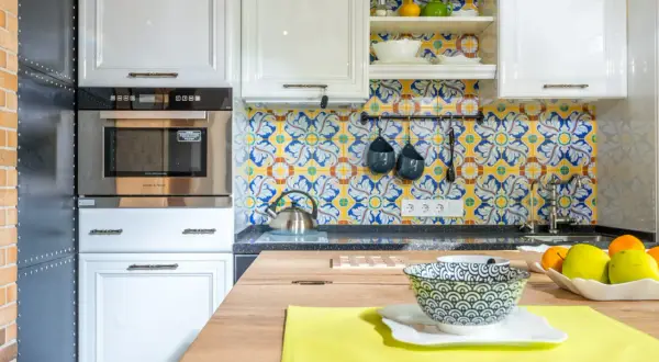 Azulejos vibrantes con motivos florales y geométricos ofrecen fantásticas ideas para pared de cocina. Blanco y azul sobre amarillo crean un ambiente alegre.