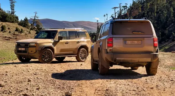 Dwa nowe Toyota Land Cruiser 2024 na pustynnym szlaku, gotowe na przygodę.