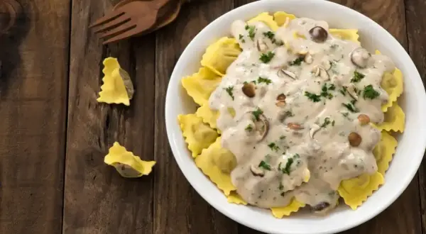Pyszne ravioli w kremowym sosie śmietanowym z grzybami i natką pietruszki. Idealny sos śmietanowy do makaronu.