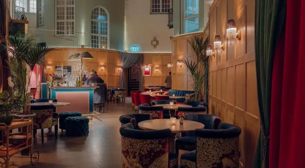 Elegant jazz bar i Stockholm med sammetssoffor, mönstrade stolar och en stilfull bar.