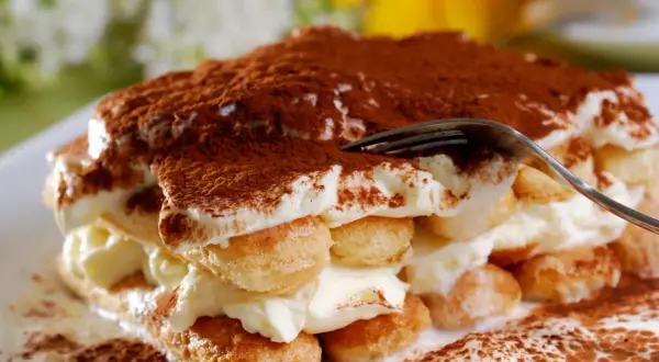 Un tiramisu crémeux, saupoudré de cacao. Pour un goût optimal, demandez-vous combien de temps laisser reposer un tiramisu au frigo.