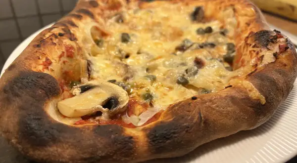En nybakad pizza med svamp och kapris, perfekt för ett mysigt kvällsmål. Detta är ett fantastiskt pizza recept!