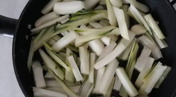 Coste di sedano tagliate a bastoncini e pronte per essere saltate in padella.