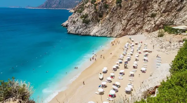 Piękna plaża z turkusową wodą i leżakami, idealne miejsce na wakacje. Alanya atrakcje zachwycają!