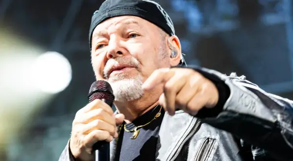 Vasco Rossi canta con passione, puntando il dito. I suoi testi, come "non mi va", risuonano potenti.