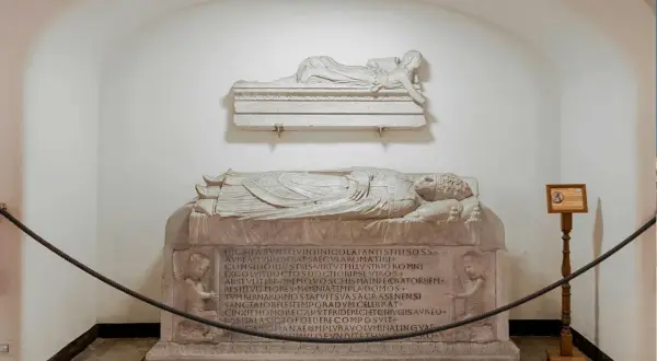 Sarcofagi scolpiti, uno con angeli, che illustrano il necropoli significato. Un'antica tomba con iscrizioni latine.