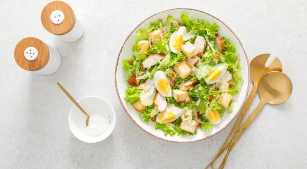 Insalata di pollo sfiziosa con uova sode, crostini e scaglie di parmigiano. Perfetta per un pranzo leggero e gustoso.