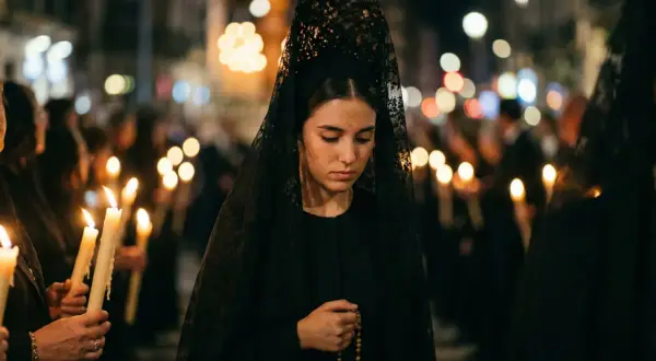 Joven con mantilla negra y rosario, participando en una procesión nocturna. El protocolo para vestir de mantilla se respeta.