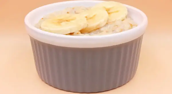 Pyszna owsianka z bananem w szarej miseczce, idealna na zdrowe śniadanie.