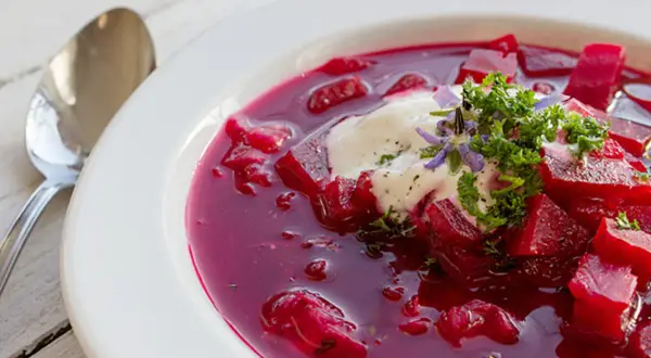 Herzhafte Rote-Bete-Suppe mit einem Klecks Sauerrahm und frischer Petersilie. Ein köstliches Gericht, das an Borretsch Rezepte erinnert.