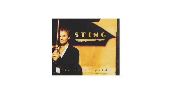 Sting trzymający laskę na tle złotej ściany z napisem "Fields of Gold".