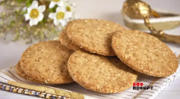 En hög med runda, gyllene digestivekex med sesamfrön. Perfekt för ett enkelt digestivekex recept.
