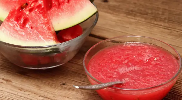 Frische Wassermelonenscheiben in einer Schüssel und eine Schüssel mit leckerer, selbstgemachter Melonen Marmelade.
