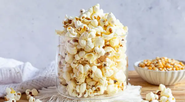 Ein Glas voller frisch gemachtem Popcorn, perfekt für einen Filmabend. So einfach ist Popcorn selber machen!