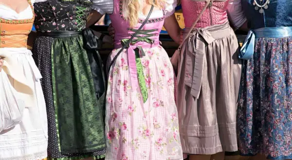 Fünf Frauen in farbenfrohen Chiemgauer Trachten, Dirndl mit Blumenmuster und Spitzenbesatz.