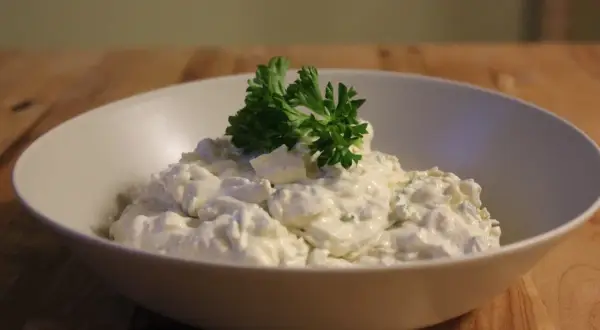 En skål med krämig tarator djej, toppad med färsk persilja.