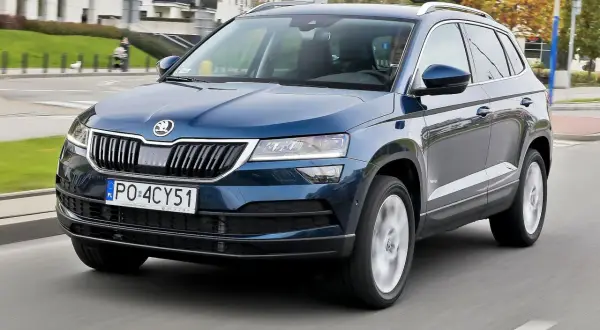 Niebieska Skoda Karoq w ruchu miejskim. Wiele osób szuka skoda karoq opinie przed zakupem.