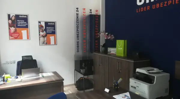 Biuro firmy ubezpieczeniowej Unilink z plakatami, drukarką i meblami.