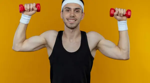 Ein Mann mit Stirnband und Schweißbändern macht Unterarmtraining mit roten Hanteln.