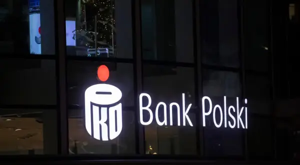 Świecący napis PKO Bank Polski. W tle choinka i odbicia. Inwestorzy liczą na dywidendę PKO BP.