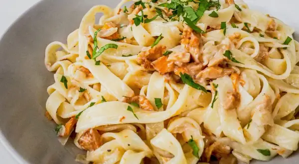 Tagliatelle w kremowym sosie kurkowym, posypane świeżą natką pietruszki. Pyszne danie, które zachwyci każdego miłośnika grzybów.