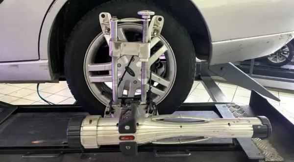 Réglage du parallélisme voiture avec un appareil de mesure sur une roue.