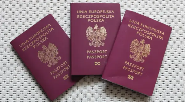 Trzy polskie paszporty, gotowe do podróży. Sprawdź wymagania paszportowe przed wyjazdem.